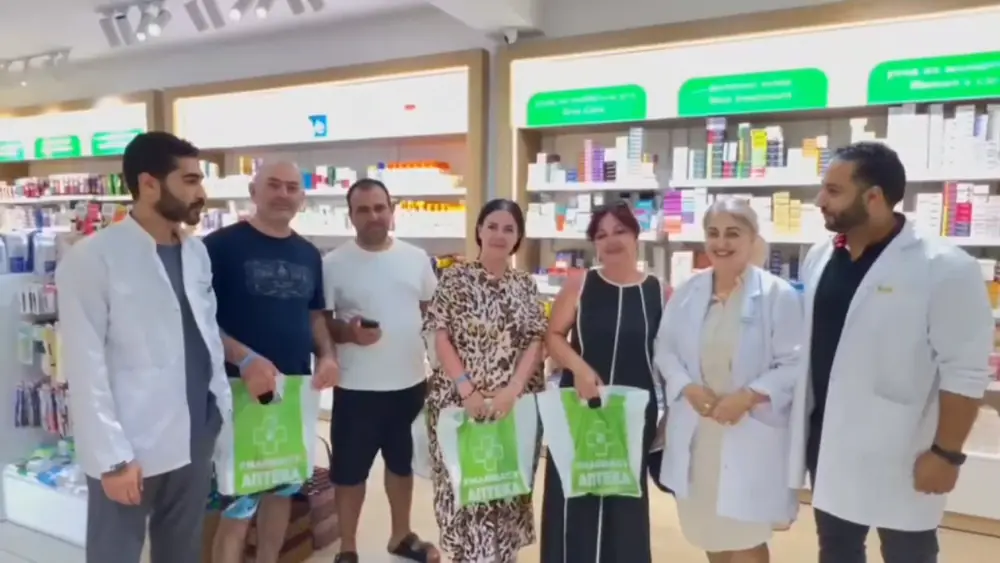 Un gruppo di clienti con due farmacisti di Apteka Sharm
